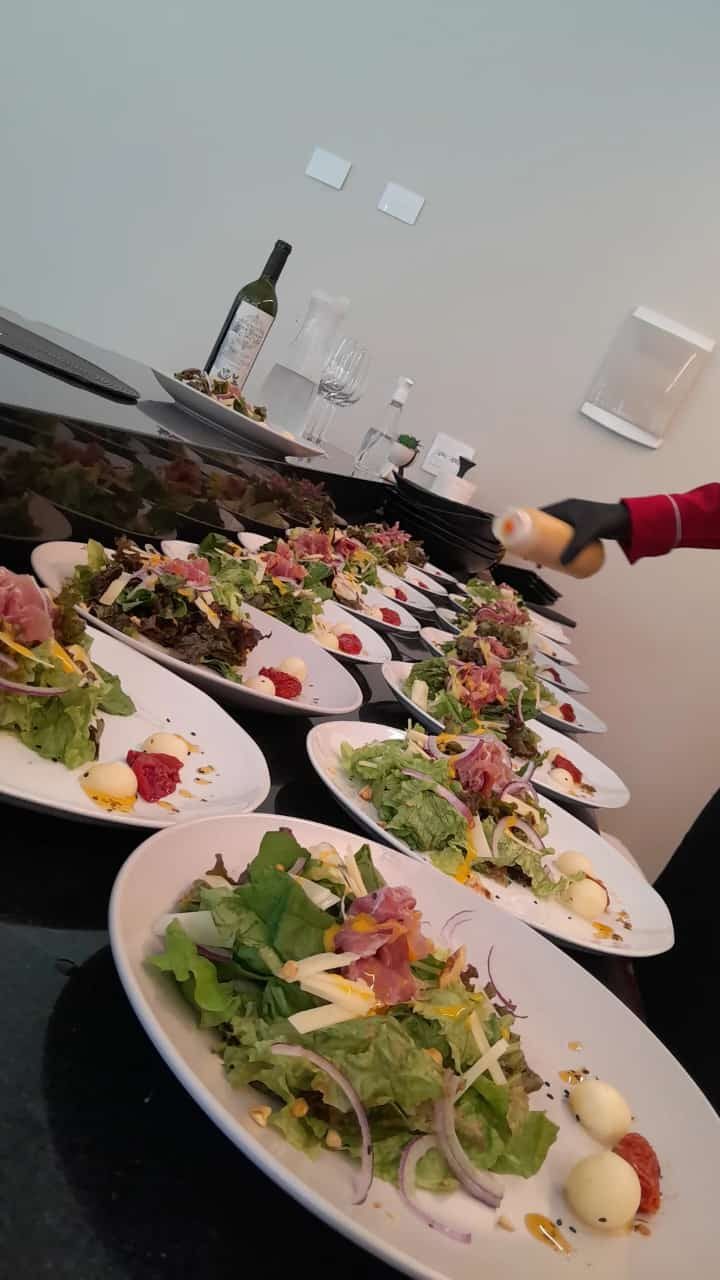 Pratos de salada sendo finalizados no buffet do evento