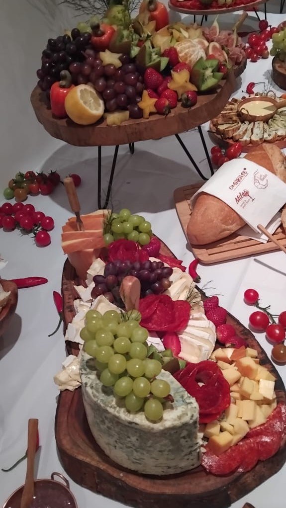 Tábua de queijos com gorgonzola, uvas, morangos e antepastos sobre a mesa de entradas