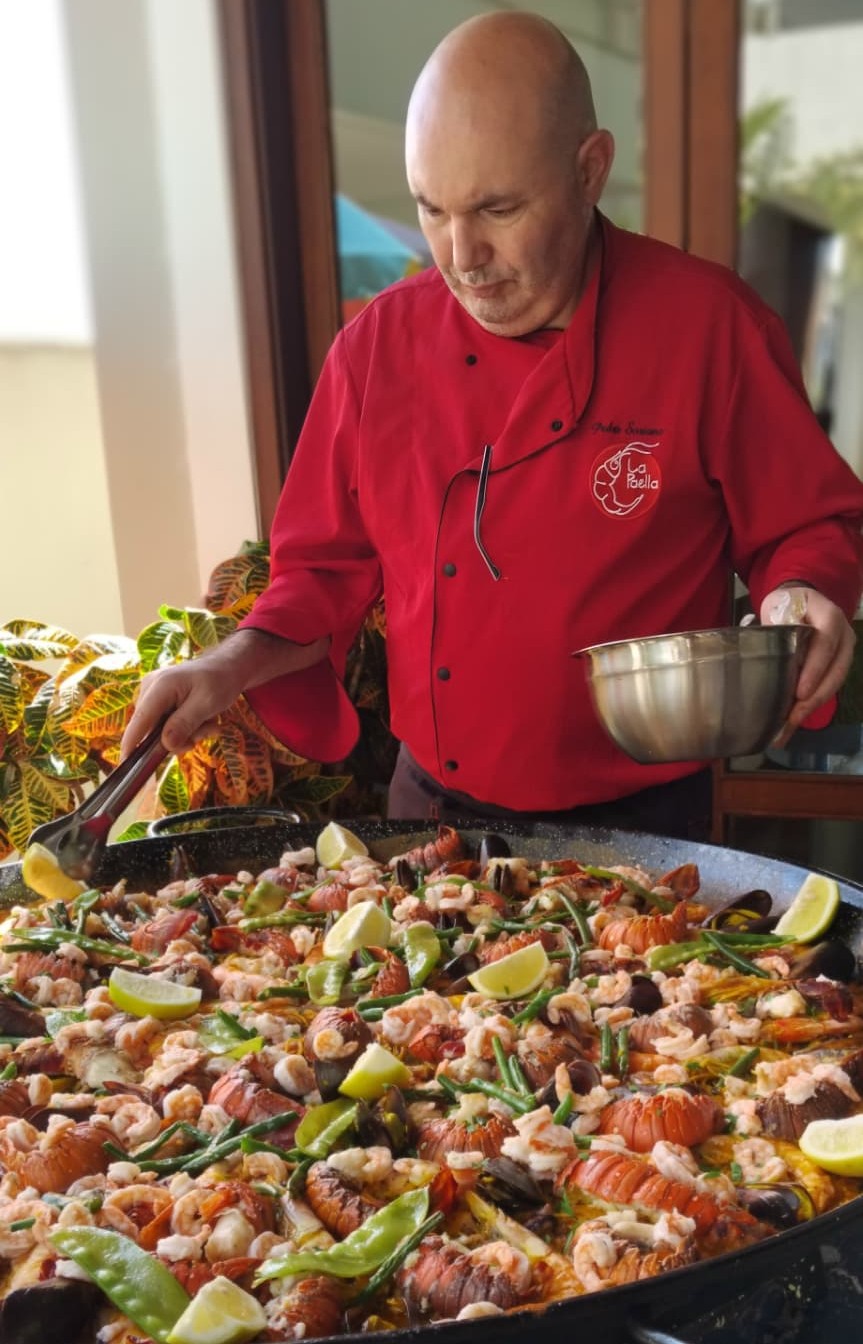 Chef Pedro Soriano finalizando a paella de lagostas ao vivo no evento