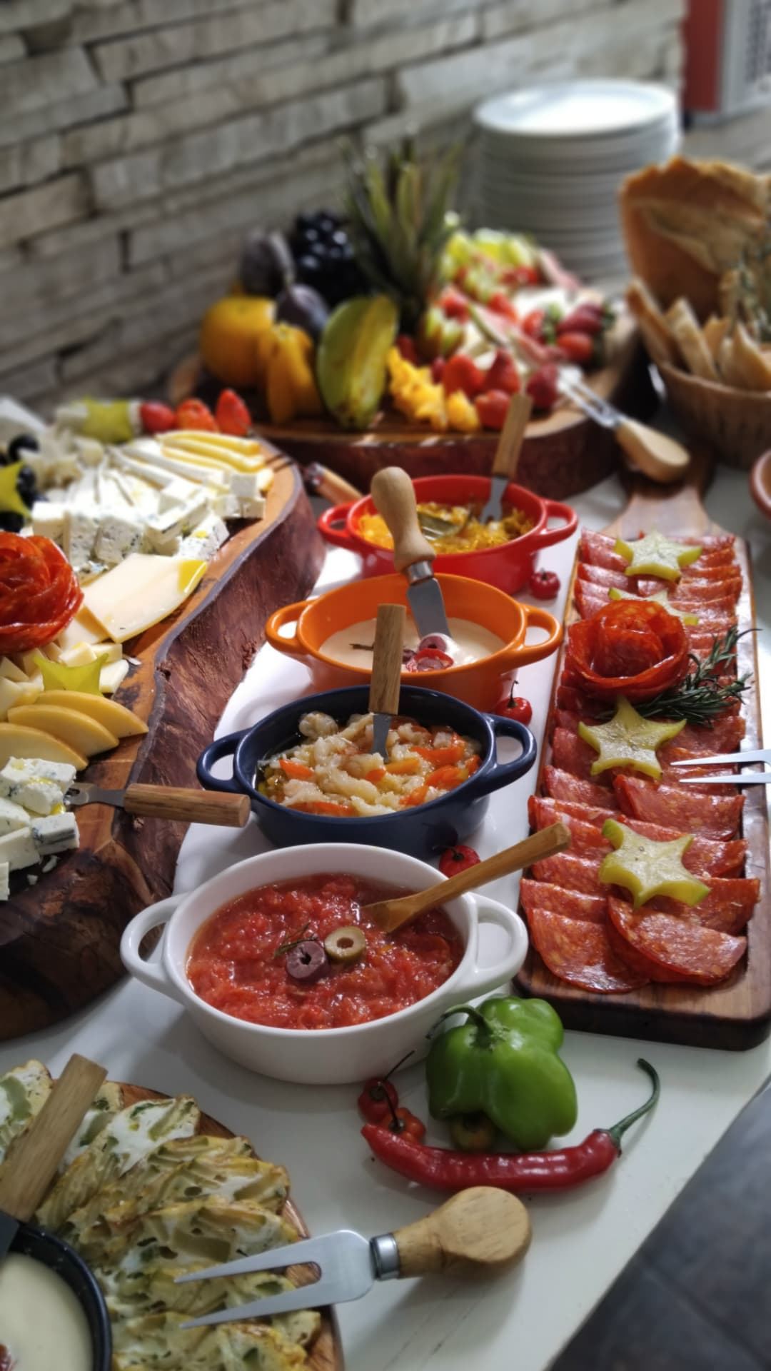 Mesa de entradas e antepastos vista de cima, com queijos, embutidos, molhos e frutas